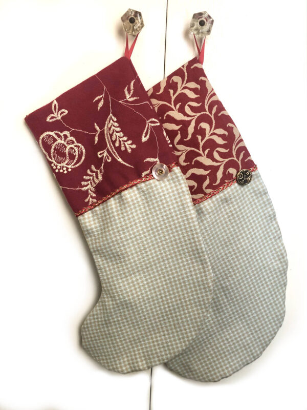 light plaid stockings with red pattern trim hang from knobs. These are beautiful and texturally pleasing.