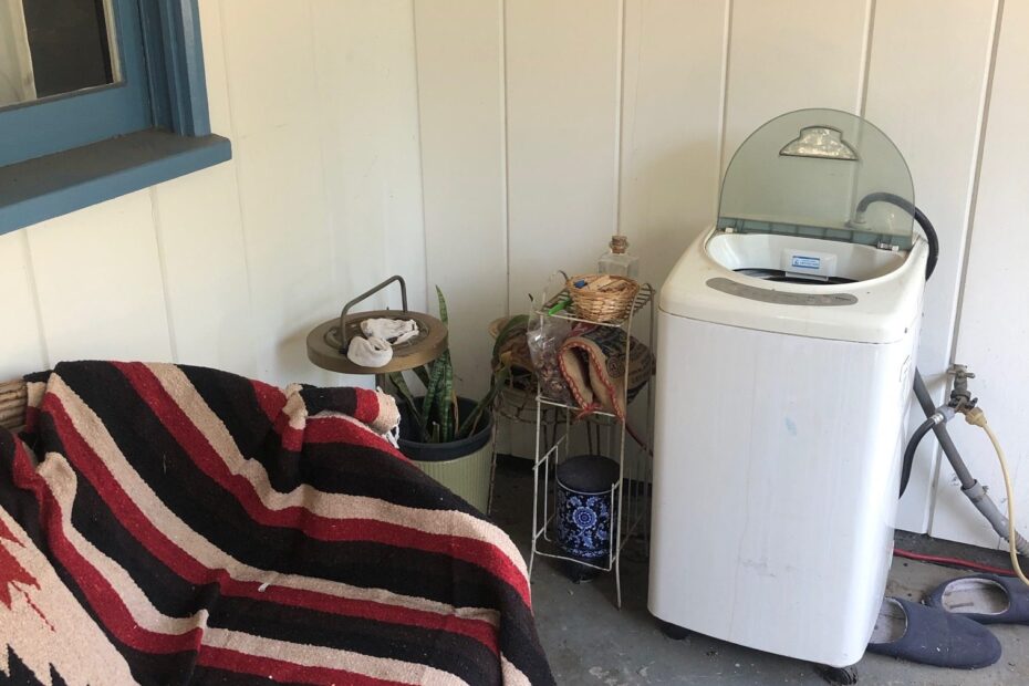 easy laundry greywater line. Washing machine on back patio next to outdoor couch.
