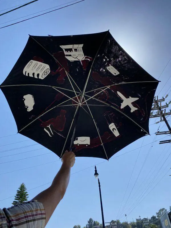 art by diana kohne shows an umbrella with images in each umbrelly segment. Images are: a steak, a delivery truck, a throwaway coffee cup, airplane, major bank credit/debit card, a large home, an a/c unit and an SUV.